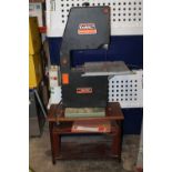 A DEWALT BS1310 BAND SAW ON MAHOGANY STAND WITH INSTRUCTIONS