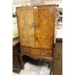 A 20TH CENTURY BURR WALNUT DRINKS CABINET ON CABRIOLE SUPPORTS - NO BACK OR SHELF