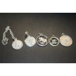 FOUR SILVER ZODIAC SIGN PENDANTS TOGETHER WITH A CHILD'S TEDDY BEAR BRACELET