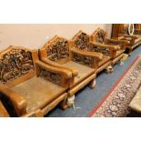 A HEAVILY CARVED HARDWOOD SALON SUITE WITH LONG SETTEE AND FOUR ARMCHAIRS, CARVED WITH ELEPHANTS