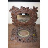 TWO BLACK FOREST STYLE HEAVILY CARVED FRAMES TO INCLUDE ONE WITH MIRROR - LARGEST 47 X 36 CM (2)