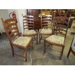 A SET OF FOUR OAK LADDER BACK DINING CHAIRS