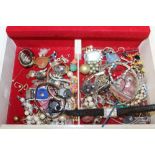 A RED LEATHER JEWELLERY BOX CONTAINING COSTUME JEWELLERY TO INCLUDE RINGS, PENDANTS, NECKLACES ETC
