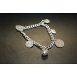 A STERLING SILVER CHARM BRACELET WITH FIVE CHARMS