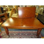 A MID VICTORIAN MAHOGANY WIND-OUT DINING TABLE RAISED ON HEAVY FLUTED SUPPORTS WITH ONE EXTRA LEAF