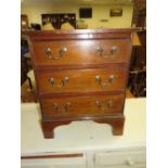 A SMALL REPRODUCTION MAHOGANY CHEST OF THREE DRAWERS