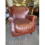 A MODERN RETRO STYLE LEATHER ARMCHAIR WITH METAL DETAIL A/F FOOT OFF