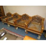FOUR HEAVILY CARVED HARDWOOD ARMCHAIRS, CARVED WITH ELEPHANTS WITHIN A LANDSCAPE,