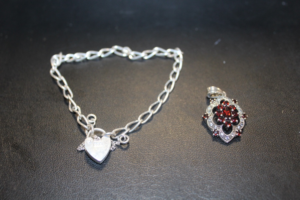 A STERLING SILVER BRACELET WITH HEART LOCK TOGETHER WITH A SILVER AND GARNET PENDANT (2)