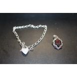A STERLING SILVER BRACELET WITH HEART LOCK TOGETHER WITH A SILVER AND GARNET PENDANT (2)