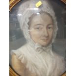 A GILT FRAMED AND GLAZED OVAL PASTEL PORTRAIT STUDY OF A LADY IN A BONNET - H 44 CM BY W 36 CM