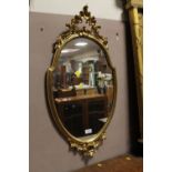 A MODERN GILT WALL MIRROR - H 83 CM