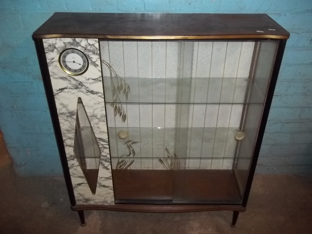 A CHINA DISPLAY CABINET WITH INTEGRAL CLOCK