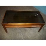 A REAK RETRO COFFEE TABLE WITH SMOKED GLASS TOP AND A STRETCHER SHELF