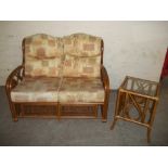 A WICKER TWO SEATER SOFA AND SMALL SIDE TABLE