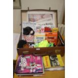 A SUITCASE OF NOVELTY ITEMS TOGETHER WITH A FEW BOOKS AND NEWSPAPERS