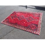 A VINTAGE RED WOOLLEN RUG 257 X 171 CM