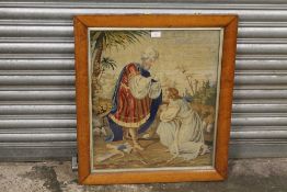 AN ANTIQUE MAPLE FRAMED AND GLAZED NEEDLEWORK STUDY OF FIGURES - H 61 CM BY 52 CM