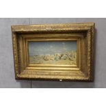 A GILT FRAMED OIL ON BOARD OF A BEACH SCENE WITH FIGURES - H 19 CM BY W 39 CM