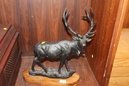 A LARGE BRONZED METAL FIGURE OF A STAG MOUNTED ON A WOODEN PLINTH