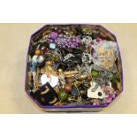 A TIN OF ASSORTED COSTUME JEWELLERY