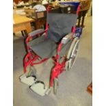 A RED LOMAX WHEELCHAIR WITH SELF PROPEL WHEELS