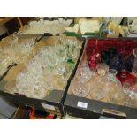 FOUR TRAYS OF ASSORTED GLASSWARE TO INCLUDE A QUANTITY OF CUT GLASS DRINKING GLASSES, COLOURED GLASS