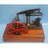 A SCRATCH BUILT CENTRAL BEAM ENGINE mounted on wooden base , with a red painted 9" fly wheel,'