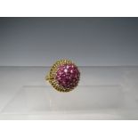 AN UNUSUAL ROSETTE STYLE GEMSET YELLOW METAL DRESS RING, the rope effect mount set with a cluster of