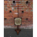 A 19TH CENTURY MAHOGANY POLE SCREEN, having a shaped glazed needlepoint adjustable floral screen,