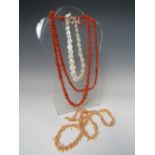 A VINTAGE 'FLAPPER' LENGTH CORAL NECKLACE, together with another coral necklace with damages, and
