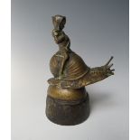 A BRONZED CAST METAL CAR MASCOT IN THE FORM OF A CHILD RIDING A SNAIL, mounted on a wooden plinth, H