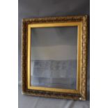 A 19TH CENTURY GOLD FRAME WITH DECORATIVE DESIGN TO OUTER EDGE AND GOLD SLIP, glazed, frame W 6.5