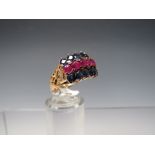 A MODERN UNMARKED YELLOW METAL GEMSET RING, the three rows of gemstones comprised of two outer