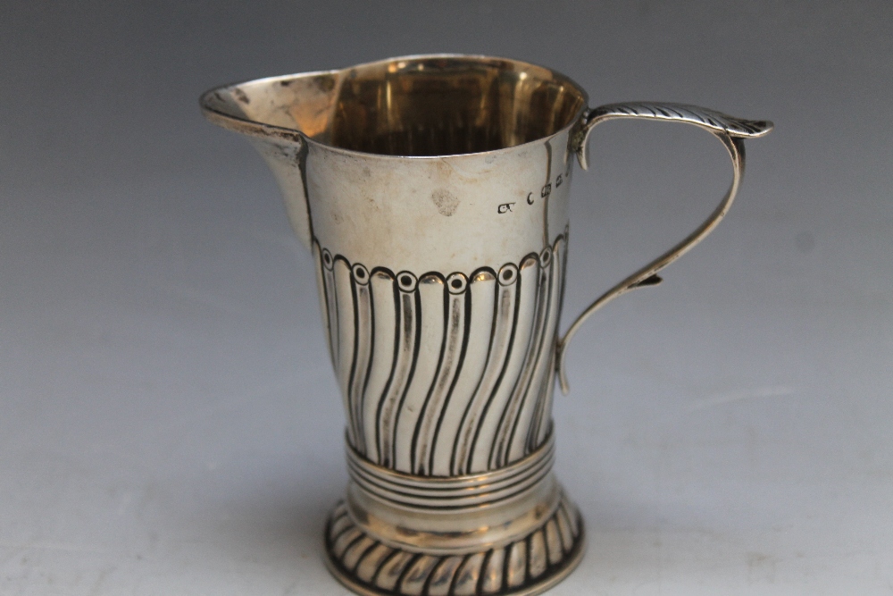 A THREE QUARTER FLUTED CREAM JUG BY GEORGE UNITE - BIRMINGHAM 1886, approx weight 115g, H 9.5 cm