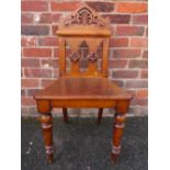 A WILLIAM IV OAK GOTHIC STYLE HALL CHAIR, with carved and pierced detail, raised on turned supports