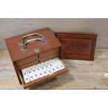 AN ORIENTAL WOODEN CASED BONE MAH JONG SET