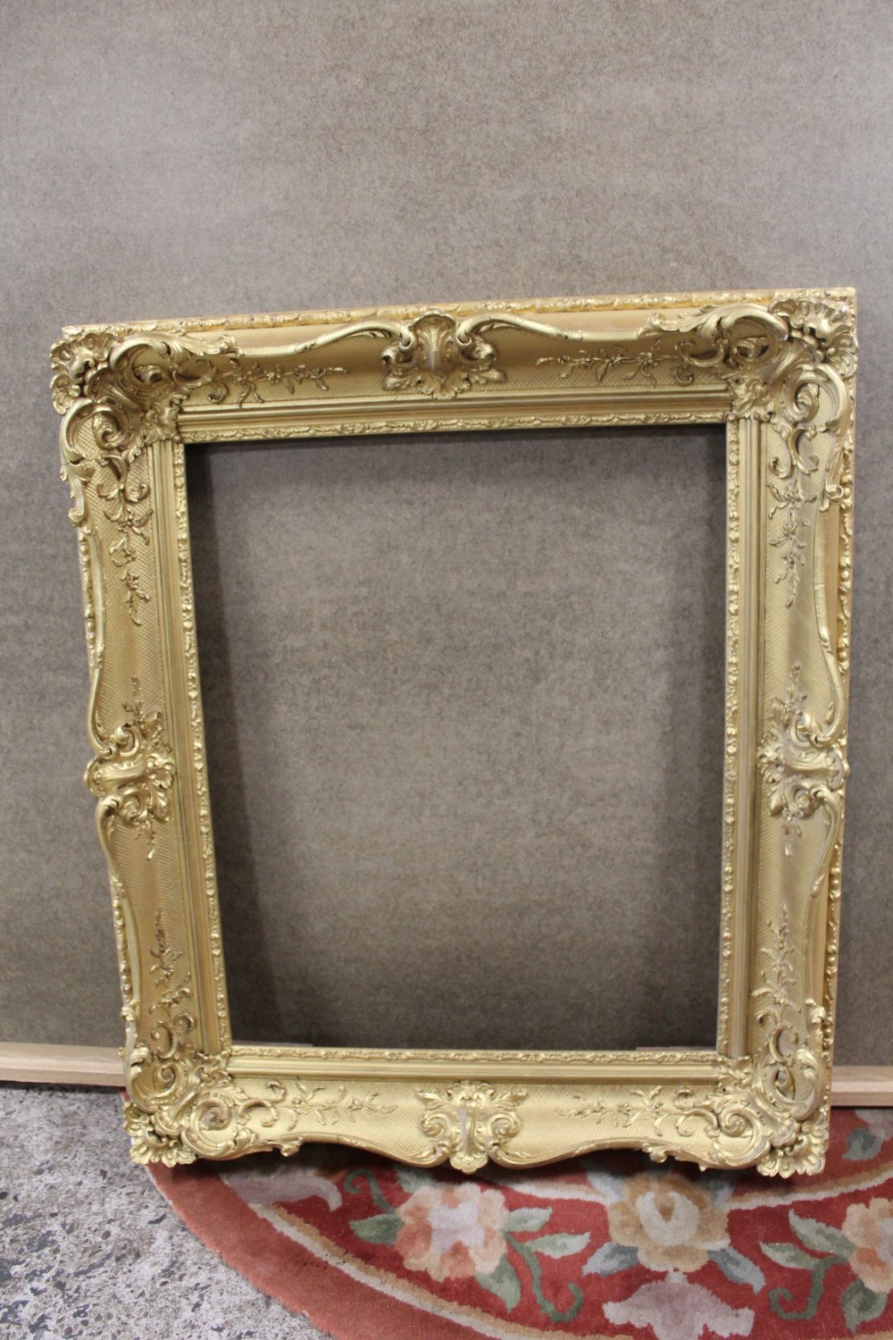 A 19TH CENTURY GILTWOOD PICTURE FRAME WITH CARVED DETAIL, REBATE 53.5 X 44 CM