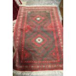 A LATE 19TH /EARLY 20TH CENTURY WOOLLEN RUG - MAINLY RED AND BLACK GROUND 151 X 100 CM