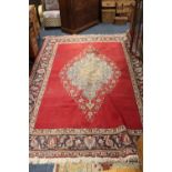 A LARGE EASTERN WOOLLEN RUG - MAINLY RED GROUND - THREADBARE IN PLACES 330 X 226 CM