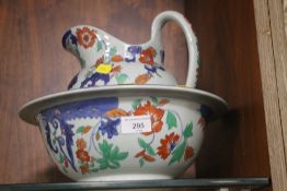 AN IRONSTONE JUG AND BOWL WITH RED BLUE AND GREEN DECORATION