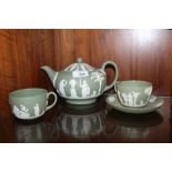 A GREEN WEDGWOOD JASPERWARE TEAPOT, TOGETHER WITH TWO TEACUPS AND ONE SAUCER