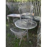 A MODERN CIRCULAR METAL PATIO TABLE AND FOUR CHAIRS