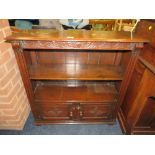 A CARVED REPRODUCTION OAK OPEN BOOKCASE WITH CUPBOARD BELOW W-85 CM