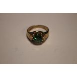 A 9CT GOLD RING SET WITH A GREEN STONE W 6 GR