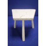 AN ANTIQUE WHITE PAINTED MILKING STOOL