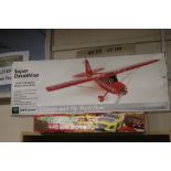 A SUPER DECATHLON REMOTE CONTROL AEROPLANE TOGETHER WITH A BOXED SCALEXTRIC SET