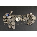 A HALLMARKED SILVER CHARM BRACELET WITH MANY CHARMS - APPROX WEIGHT 93.9 G