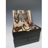 A STACKING JEWELLERY BOX AND CONTENTS, comprising of approximately 40 handcrafted bead necklaces,
