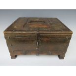 A 19TH CENTURY TABLE TOP WOODEN BOX, with carved decorations and metal bindings, H 19 cm, W 34 cm, D